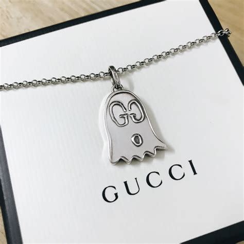 gucci ghost necklace on neck.